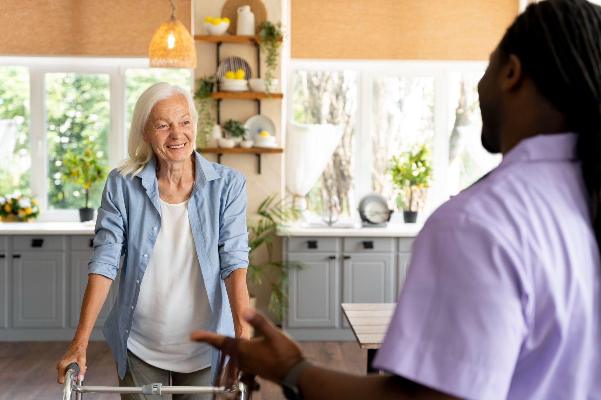 caregiver having a friendly conversation with a senior woman at home to provide companionship and support